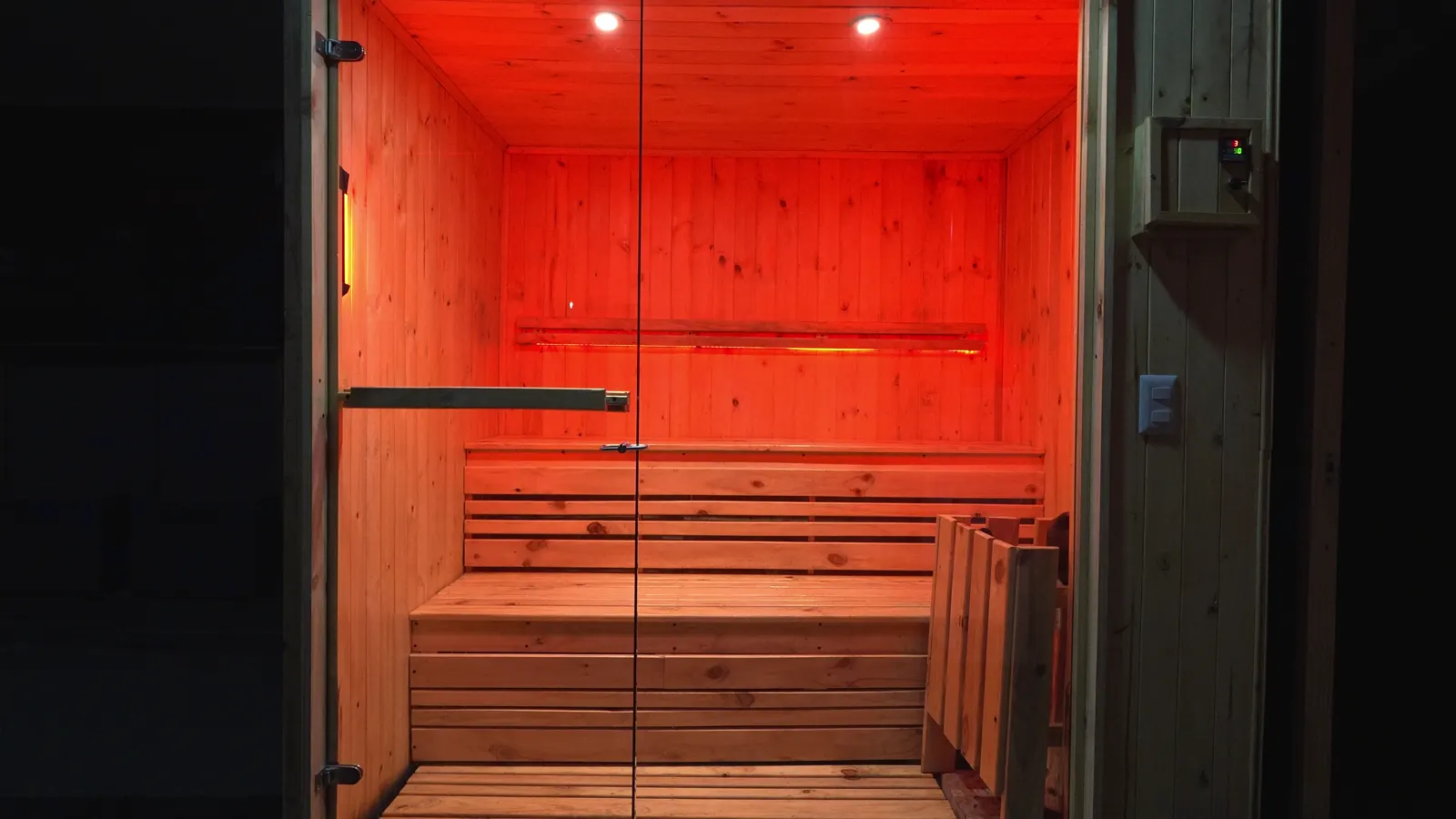 La cabina del sauna, de madera y luz roja