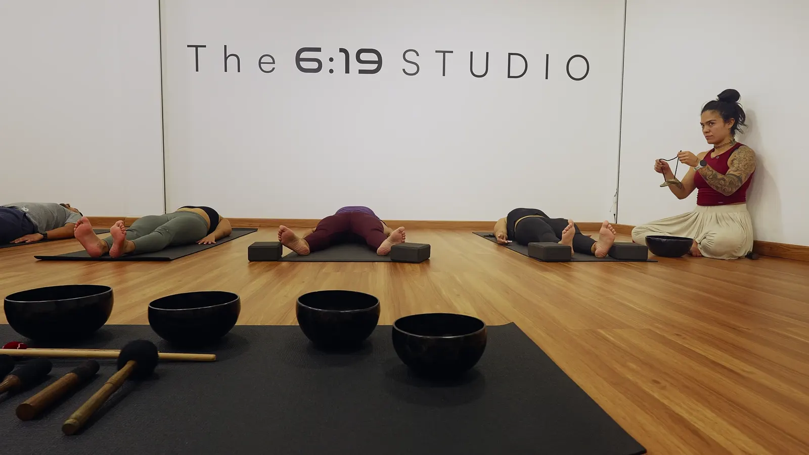 Clase de yoga con cuencos tibetanos en la sala de The 6:19 Studio