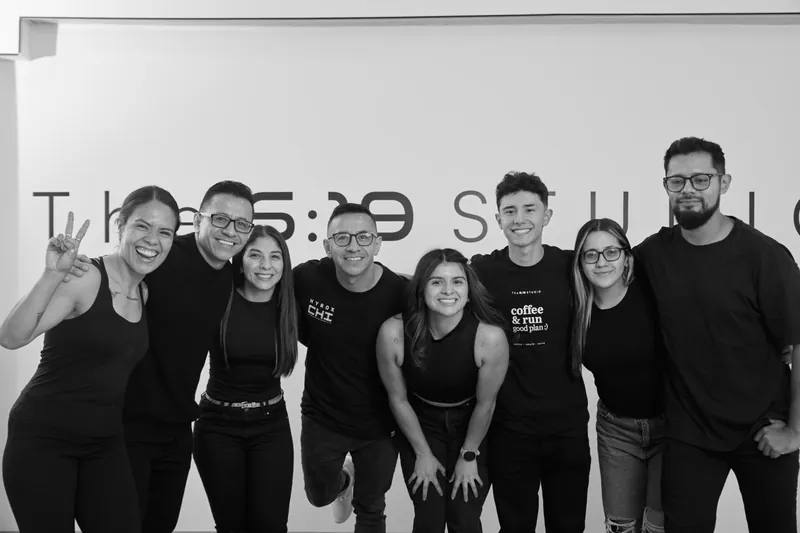 El equipo en fila, vestido de negro, en la sala del Studio