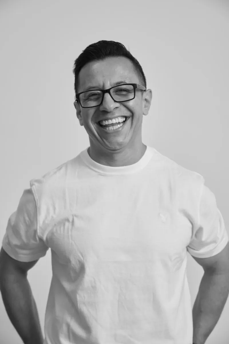 Retrato de un coach riendo, con camiseta blanca