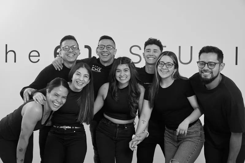El equipo abrazado y riendo frente al letrero de The 6:19 Studio