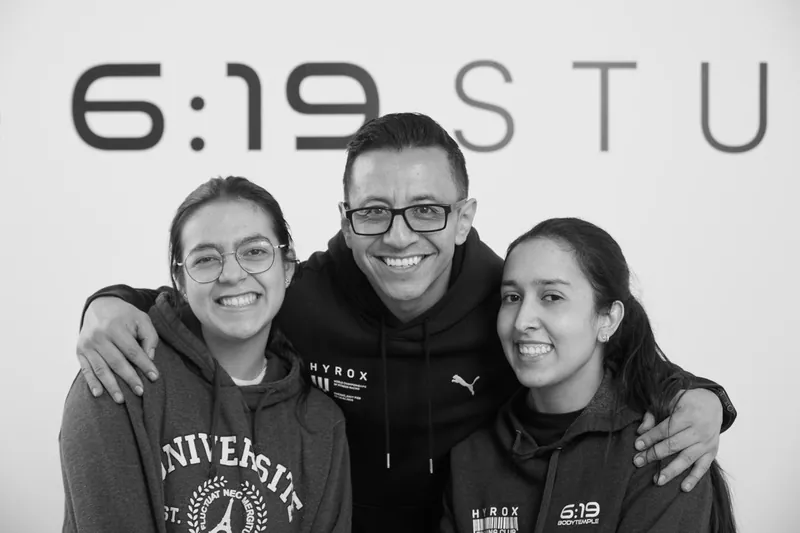 Tres integrantes del equipo abrazados y sonriendo